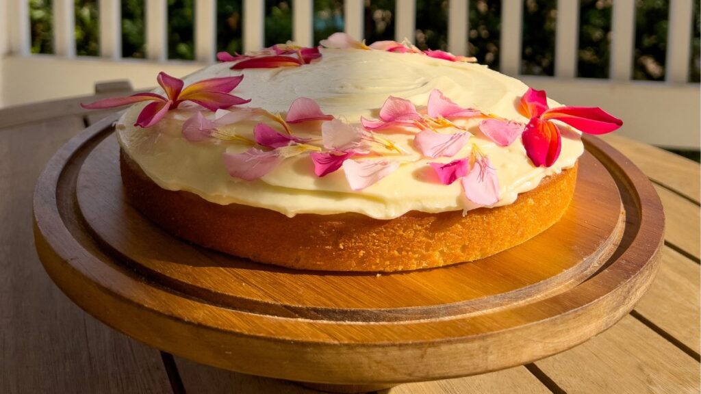 Frosted olive oil cake on cake stand