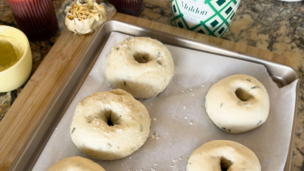 Unbaked bagels on baking sheet